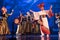 Group of actresses in traditional kimono and hats dancing with taiko drummers on the stage