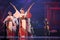 Group of actresses in traditional white and red kimono and fox masks dance and drum a big taiko