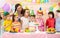 Group of adorable kids gathered around festive table. Birthday party for preschoolers