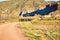 group of adult people with colorful backpack trekking on a path of sand and stones walking to mountain with a amazing landscape on