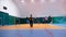 Group of adult people plays volleyball in gym.