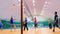 Group of adult people plays volleyball in gym.