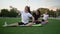 Group of adult women doing yoga in nature. Fitness stretching workout sitting on the grass in the park. Fitness, sport