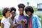 Group of african american young adults posting message with digital tablet