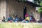 Group of African Black People Women and kids Sitting near the Rural home made of sticks and mud with thatched house in