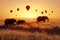 A group of African elephants against the sky with balloons at sunset. African fantastic image. Africa, Tanzania, Serengeti Nationa