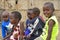 Group of African little children near traditional adobe house