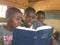 Group of African school kids reading Bible.
