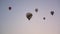 Group of air balloons glides in clear blue sky in morning