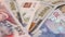 Group of American Banknotes of 100 Dollars and Georgian Lari on Rotating Table. Closeup,