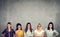 Group of angry negative young women looking at camera while standing against concrete wall background