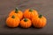 Group of artificial pumpkins over brown wooden background