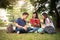 Group of Asian college student reading books and tutoring special class for exam on grass field at outdoors. Happiness and