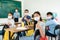 Group of Asian elementary school students and teacher wearing hygienic mask to prevent the outbreak of Covid 19 in classroom while