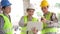 Group of Asian engineer or Young Female Architect put on a helmet for safety and talk with a contractor on a construction building