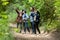 Group asian friends traveler with backpack adventure holding map to find directions and walking relax in the jungle forest outdoor