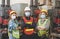 Group of Asian male and female engineers wearing hygienic mask protect with helmet safety in factory