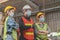 Group of Asian male and female engineers wearing hygienic mask protect with helmet safety in factory