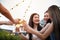 Group of asian multiple gender holding glass of wine chat together with friends while celebrating dance party on outdoor rooftop