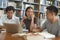 Group of asian students researching for project in library of university