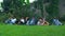 a group of Asian teenagers relaxing on a green meadow with their friends on a school holiday