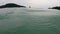 Group of asian tourist playing in the sea. light rain droplet drop into calm sea water at tropical island. female friends talking