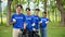 A group of Asian volunteers with garbage bags are standing in the park and showing their fists