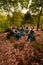 A Group of Asian women takes a vacation to the forest while wearing a green skirt and sitting on a rock