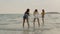 Group of Asian women using mobile phone photography and playing on beach, Beautiful female relax on beach near sea when sunset in