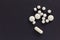Group of assorted white tablets. Black background.