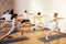 Group of athletic attractive people are practicing yoga class with instructor in gym. Young multiethnic women and men lunge with