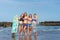 group of attractive women in bikini with surfboard posing in front