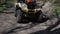 A group of ATV riders and a motorcyclist ride on a dirt road in the woods. Front view in motion. Extreme type of outdoor