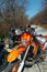 Group of ATVs and motocross bike parked on road in forest