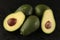 Group of avocado with half on black background