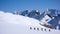 Group of backcountry skiers crossing a glacier on their way to a high summit in the Alps