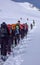 Group of backcountry skiers crossing a glacier on their way to a high summit in the Alps