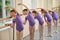 Group of ballerinas training at ballet barre.