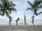 Group of beautiful asian women in bikini posting on tropical sea beach with palm tree. pregnant female traveling with friends for