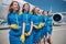 Group of beautiful young stewardesses standing outdoors in airfield
