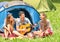 Group of best friends singing and having fun camping outdoors