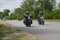 Group bikers on motorcycles ride asphalt road.