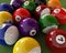Group of billiard balls with numbers, on green carpet table.