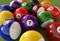 Group of billiard balls with numbers, on green carpet table.