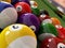 Group of billiard balls with numbers, on green pool table.