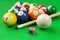 Group of billiard colored balls, cue and chalk on green table