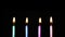 Group birthday candles light on isolated black