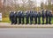 Group of black uniformed German policemen with helmet, visor, baton, securing to two sides, asphalt road in the foreground