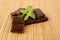 Group of blocks of chocolate with sage on wooden mat