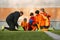 Group of boys, children training football with professional coach on field outdoors. Man showing sportive tacticsvof